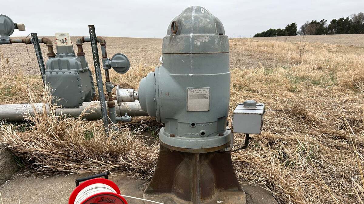 A wellhead and pump in an open field