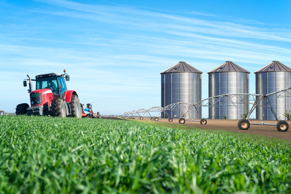 agriculture-food-production-concept-with-tractor-machine-silos-irrigation-system