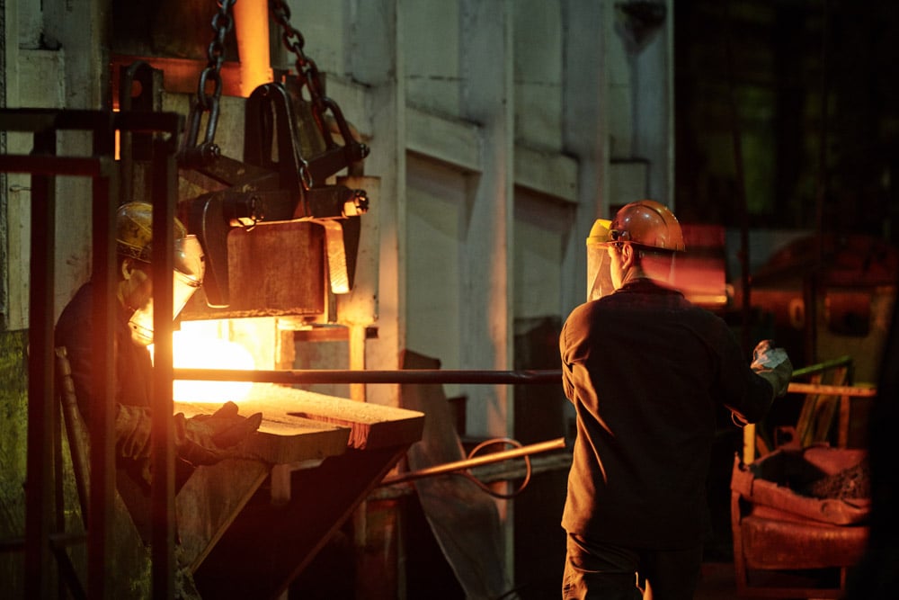 rear-view-factory-man-helmet-using-iron-stick-while-working-with-furnance-industry