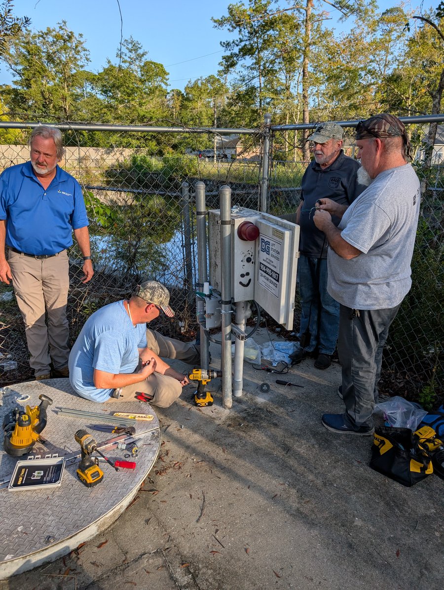 RACO team member with operators at a lift station control panel